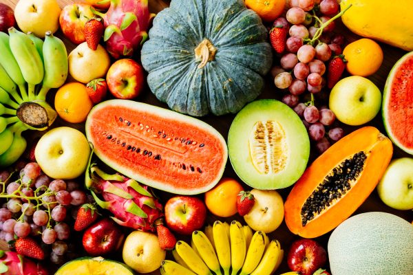 Assorted and mixed fruits on wooden background with copy space - Healthy food concept